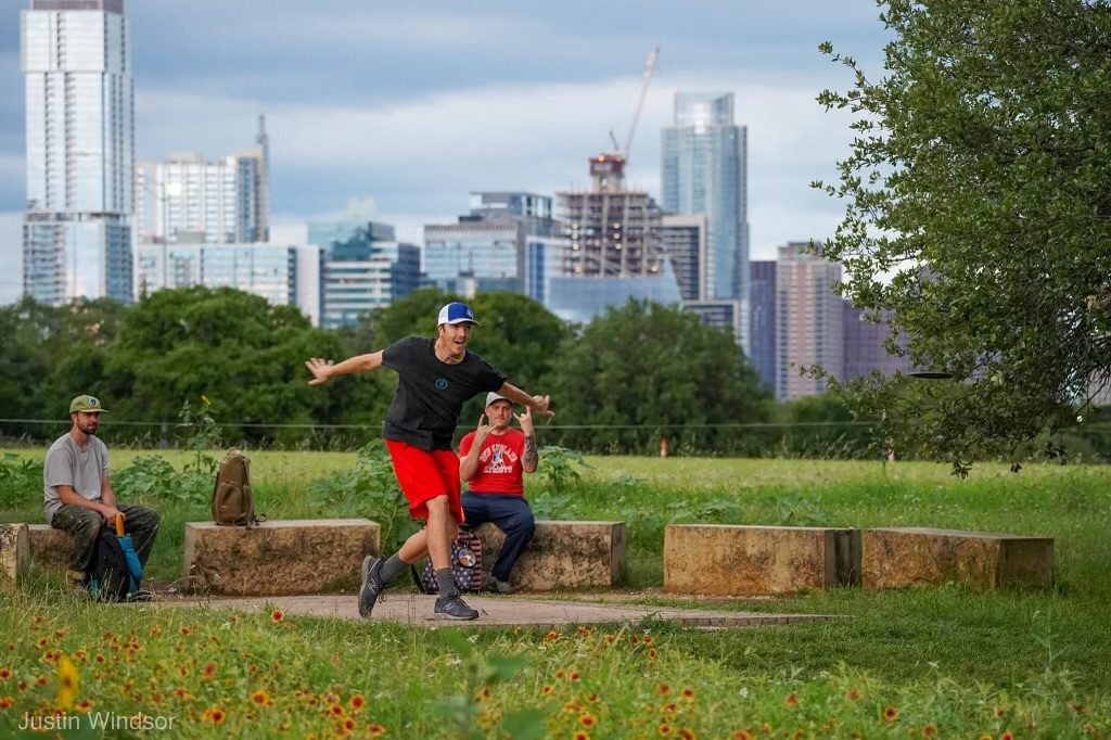 Disc golf at Zilker, Austin skyline behind. Photo by Justin Windsor